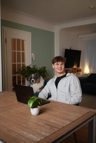 Noah am Laptop mit seinem Hund